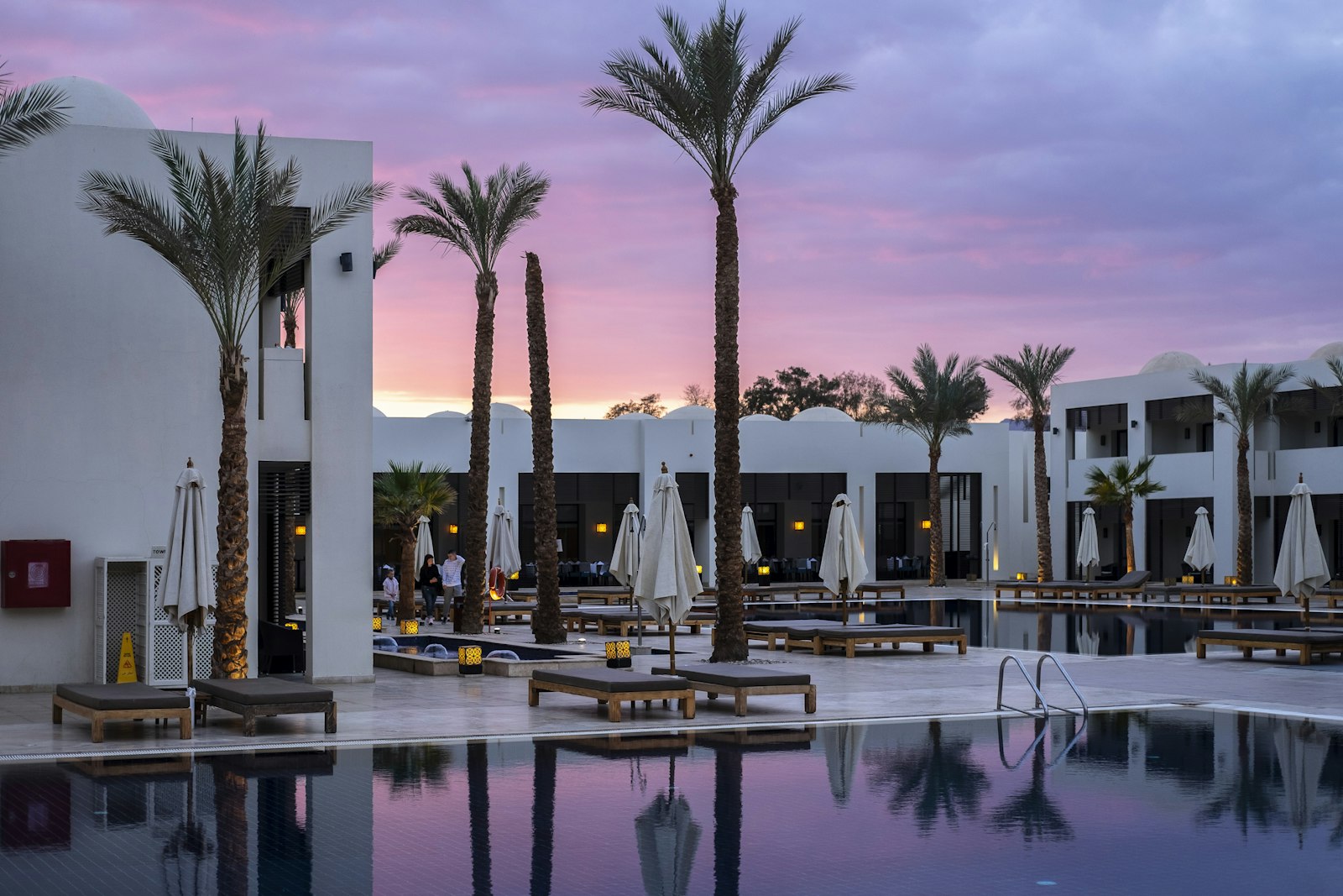 A Mediterranean grand hotel terrace with white parasols above the sea